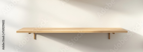 Minimalist Wooden Shelf Mounted on a White Wall in Sunlight photo