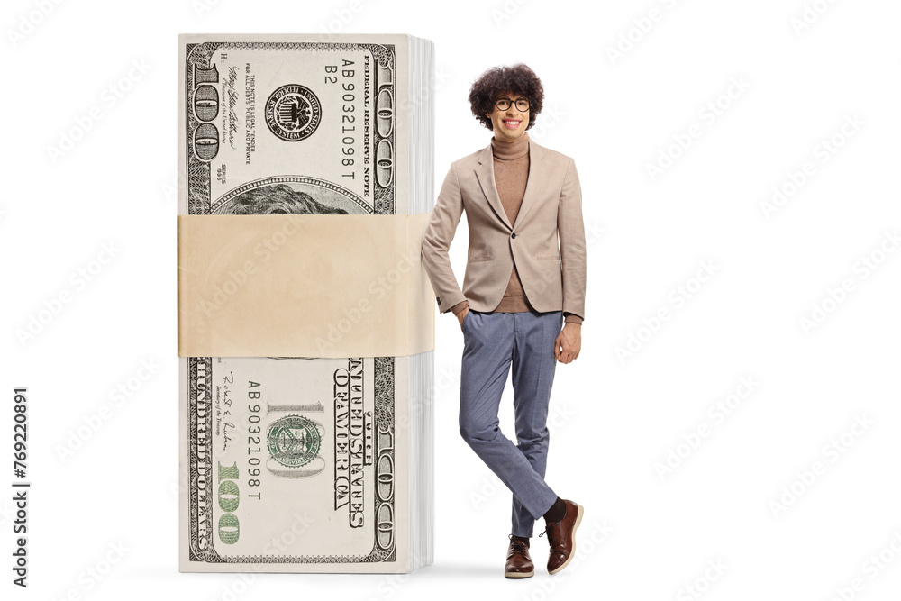 Young man leaning on a stack of money and smiling Young man leaning on a stack of money and smiling