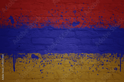 colorful painted big national flag of armenia on a massive brick wall
