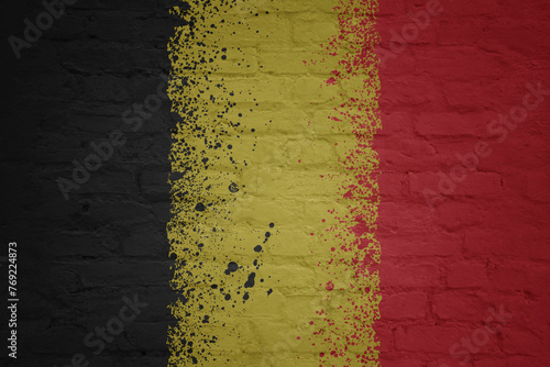 colorful painted big national flag of belgium on a massive brick wall