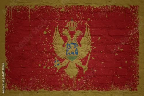 colorful painted big national flag of montenegro on a massive brick wall