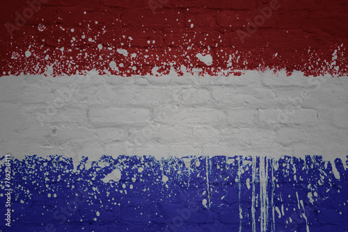 colorful painted big national flag of netherlands on a massive brick wall
