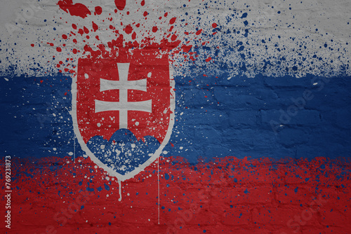 colorful painted big national flag of slovakia on a massive brick wall