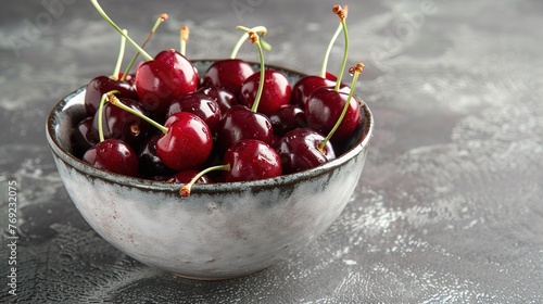 Fresh sweet cherries bowl with leaves in water drops on blue stone background  top view