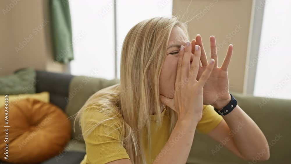 Blonde bombshell in a rage! angry young woman, confident in her t-shirt, loud and yelling in living room of her home- announcing her fury Blonde bombshell in a rage! angry young woman, confident in her t-shirt, loud and yelling in living room of her home- announcing her fury