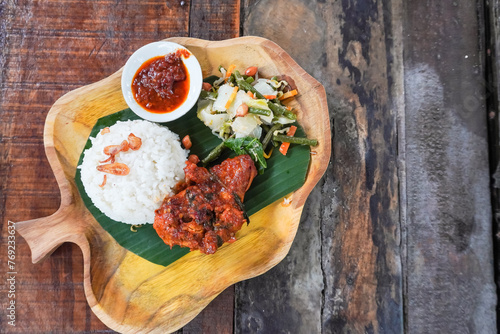 Ayam Taliwang is an authentic Indonesian food from Sumbawa, Nusa Tenggara Barat. This food consisting of spicy roasted chicken, steamed rice and stir-fried vegetables. photo