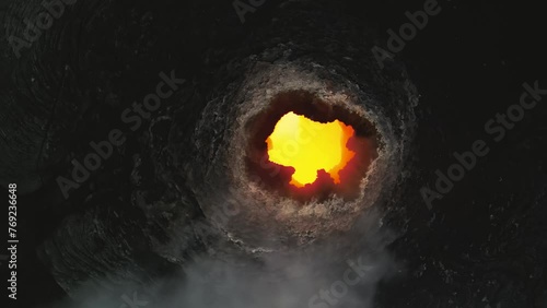 Erta Ale, Danakil Depression, Ethiopia. Top down aerial view of active volcano smoking and lava activity. Cinematic drone footage gaining altitude in a spinning orbit above the volcanic pit at sunset. photo