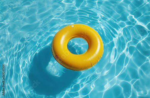 Summer vacation and travel concept. Yellow swimming ring floating on the water in a pool. Sunny summer day,.