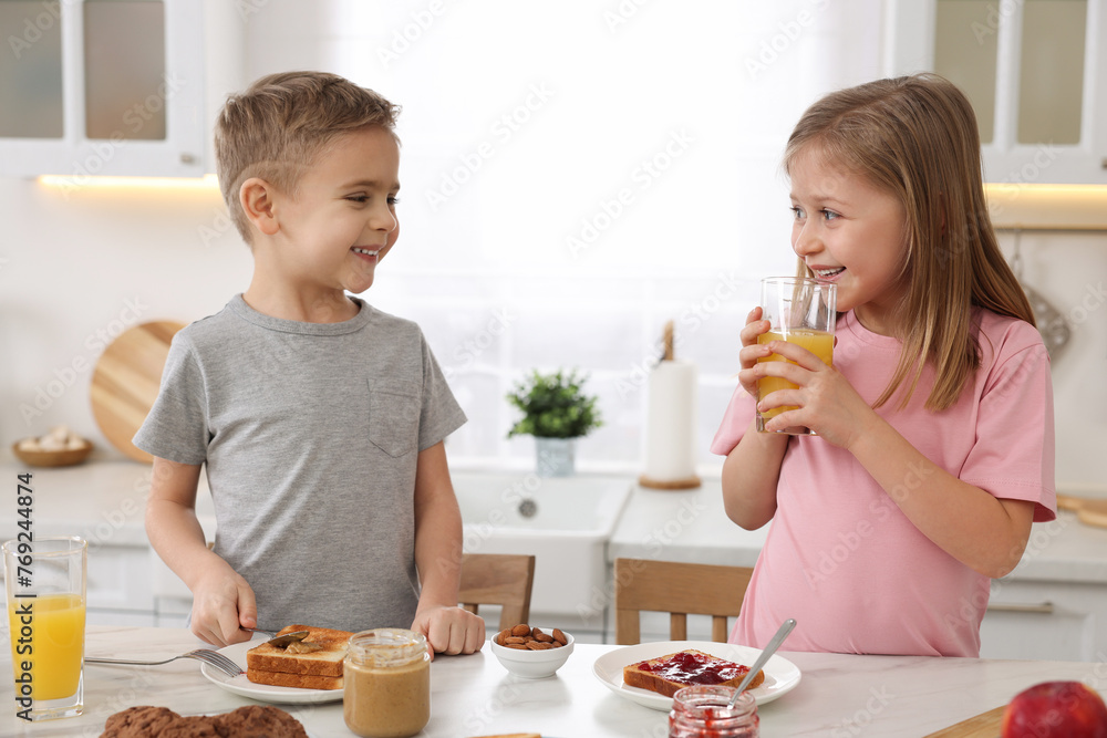 Little children having breakfast at table in kitchen Little children having breakfast at table in kitchen