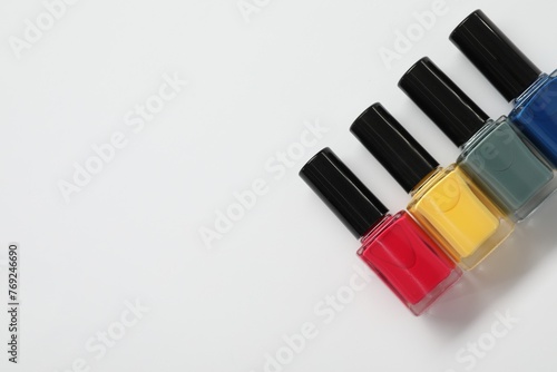 Nail polishes on white background  flat lay. Space for text