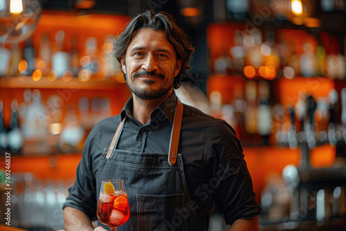 Barman preparando un cóctel con tonos anaranjados, sobre un fondo de madera en tono naranja