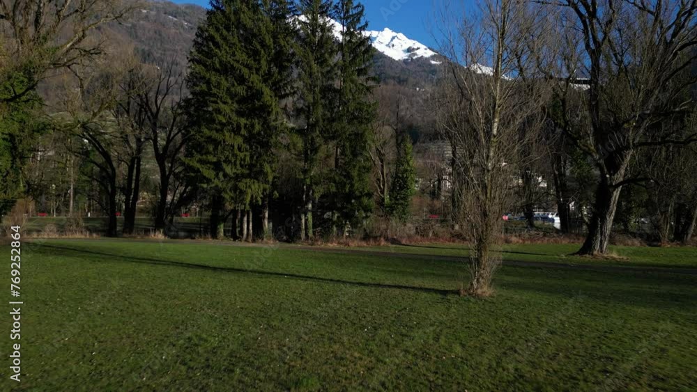 Forward drone shot of a green field with mountains at background in Walensee, Switzerland Forward drone shot of a green field with mountains at background in Walensee, Switzerland