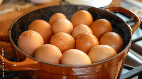 A pot filled with brown eggs sits on top of a stove, ready to be cooked. © Justlight