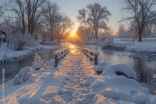 Golden sunrise seen through a snow-laden bridge over a frozen stream in a tranquil winter setting