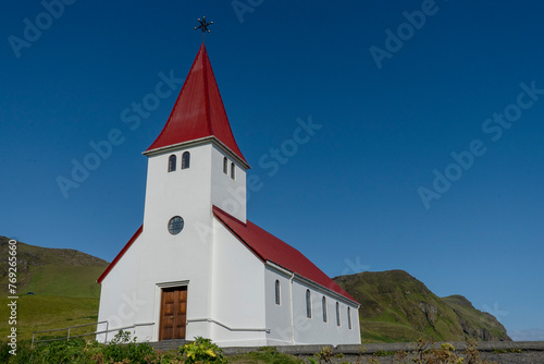 Vik i Myrdal Church, little white church with a bright red roof which sits atop a hill above Vík, Iceland. Built in 1929.