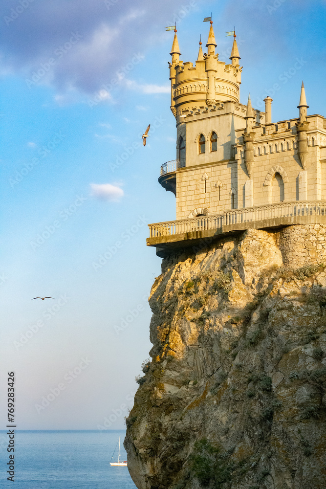 Swallow's Nest castle on the cliff in Crimea with seagulls flying in the sky sunset summer