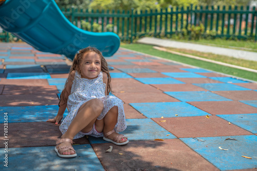 Happy girl playing alone in the floor of a playground photo