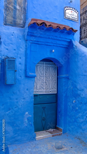 Blue, metal door in a blue wall in the medina in Chefchaouen, Morocco © Angela