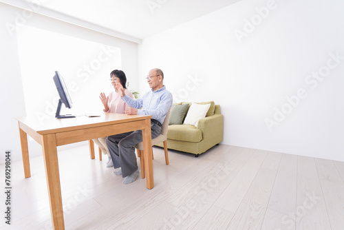 パソコンでテレビ電話をする高齢の夫婦