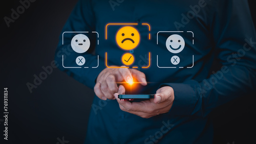 Engaging in an online customer feedback survey, a user utilizes their mobile phone to display an angry emoticon on a virtual screen, sharing their opinion and reviewing service satisfaction.