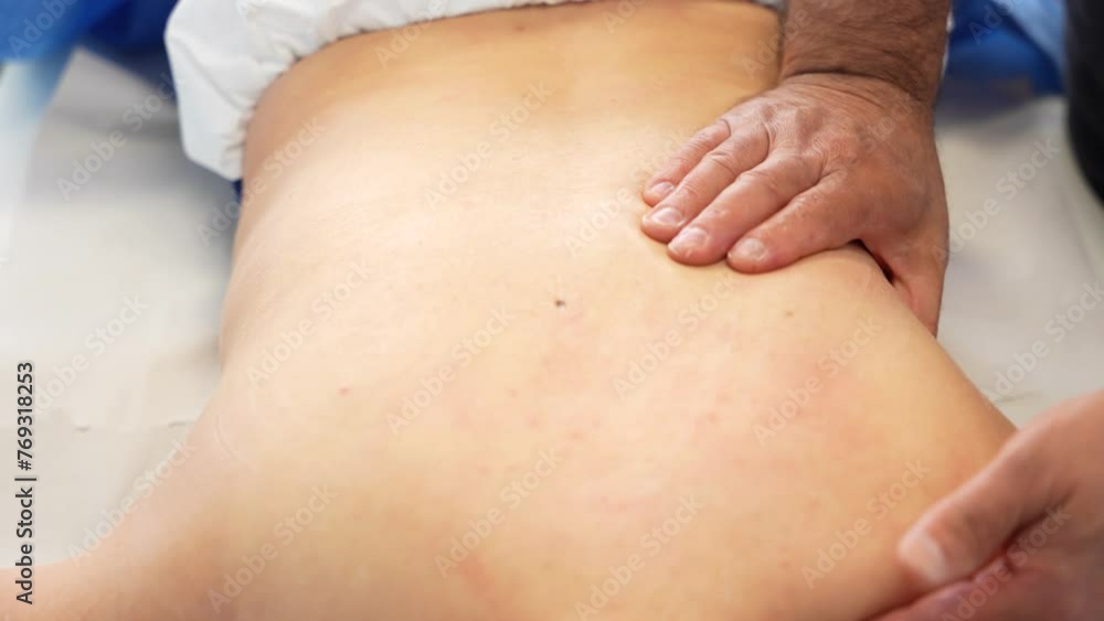 Male physiotherapist hands massage the back of female patient. Spa concept Male physiotherapist hands massage the back of female patient. Spa concept