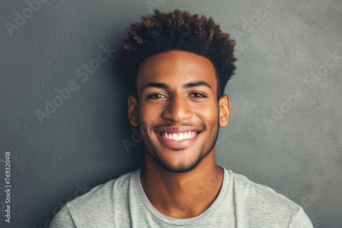 A man with a short, curly afro is smiling for the camera