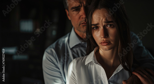 A young woman is crying and the man touches her shoulder to comfort her