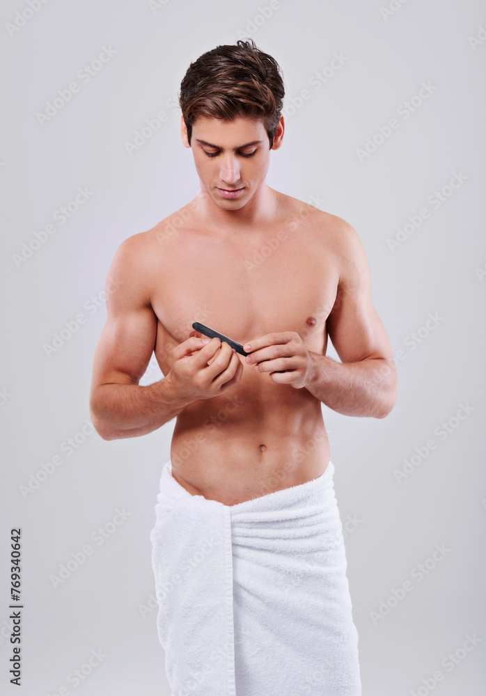 Man, nails and grooming with filler for beauty, hygiene or skincare on a gray studio background. Muscular male person or young model cleaning or filing finger tips with cosmetic tool on mockup space