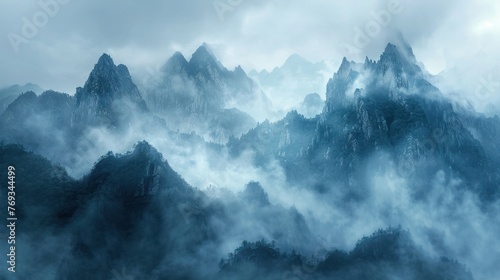 Enigmatic Peaks Amidst Mountain Mist Mystic mountain ridges loom through swirling mists, a tableau of nature's enigmatic grandeur in shades of blue and gray.