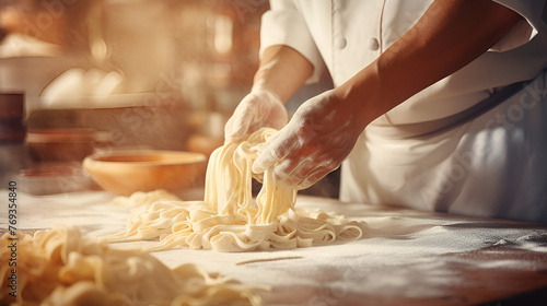 person kneading dough, Fresh pasta on table of restaurant kitchen 