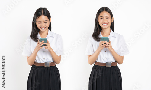 Smiling student girl in university uniform holding smartphone on white background.