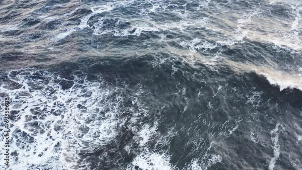 aerial view captures serene ocean waves under a mesmerizing sunset