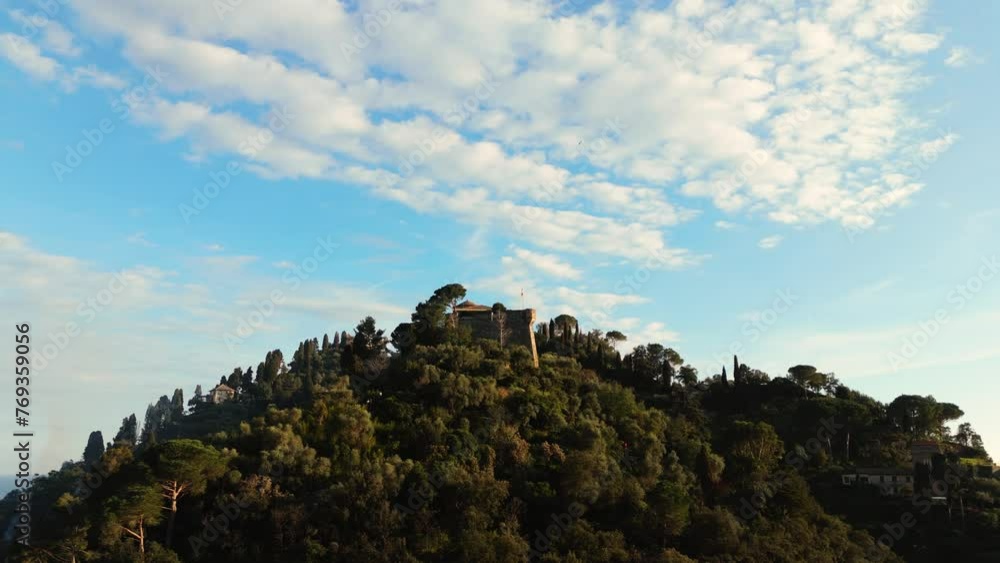 Hilltop view of Portofino at sunset with lush greenery and Mediterranean Sea backdrop, aerial shot Hilltop view of Portofino at sunset with lush greenery and Mediterranean Sea backdrop, aerial shot