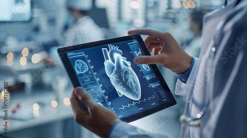 A doctor is holding a tablet with a heart image on it. A heart with a few lines and dots around it. The doctor is pointing at the heart, possibly explaining something to someone else