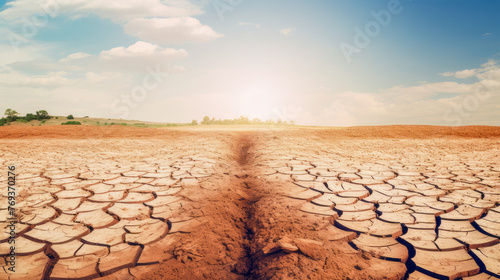 Cracked earth from lack of water and moisture against the background of the blue sky, hope for salvation.