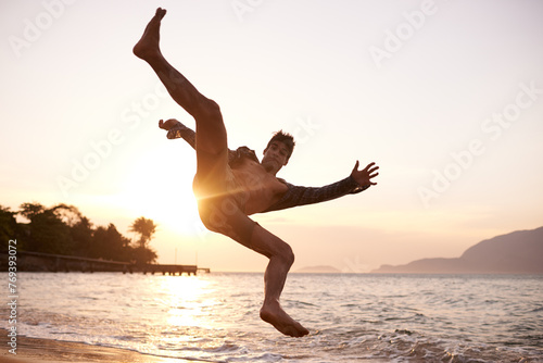 Man, dancing and breakdance with jump on beach for hip hop performance, workout training and practice. Ocean, dancer and movement with energy with sunset, stunt or flexible talent on Maldives holiday