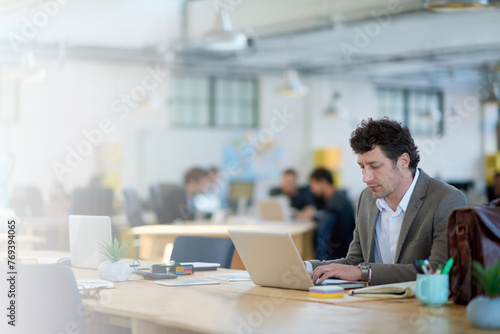 Laptop, employee and man typing for sales in startup, business and corporate company. Workplace, bookkeeper and male person working with technology, online and internet in office with notebook