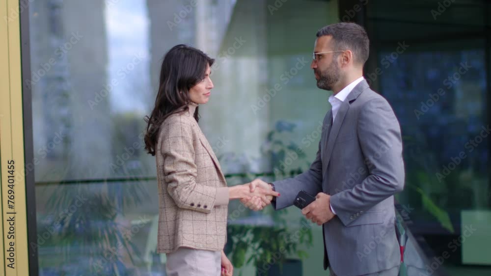 Reflective Facade Captures the Meeting of Two Professionals in a Modern Urban Setting Reflective Facade Captures the Meeting of Two Professionals in a Modern Urban Setting