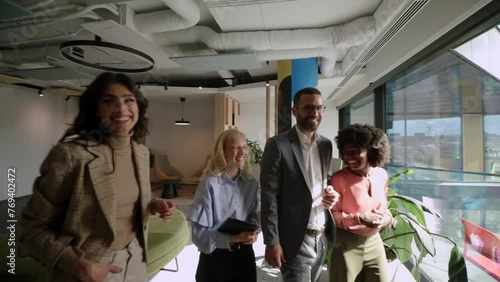 Collaborative team walks through the modern office space, sharing ideas and laughter