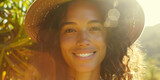 A vibrant photo of a young smiling woman wearing a sun hat