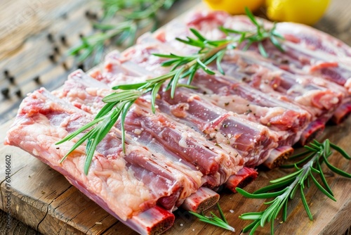 Raw pork ribs with rosemary on wooden board