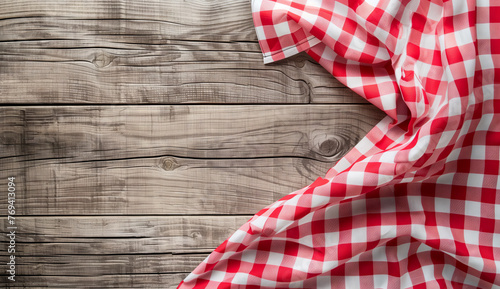 Red and White Gingham Cloth on Wooden Background. A red and white gingham cloth elegantly sprawls across a natural wooden plank background, invoking a rustic yet homely vibe.
