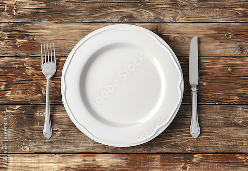 Classic Dinner Plate Setting. Simple and elegant table setting with empty white plate  fork  and knife on a wooden table.
