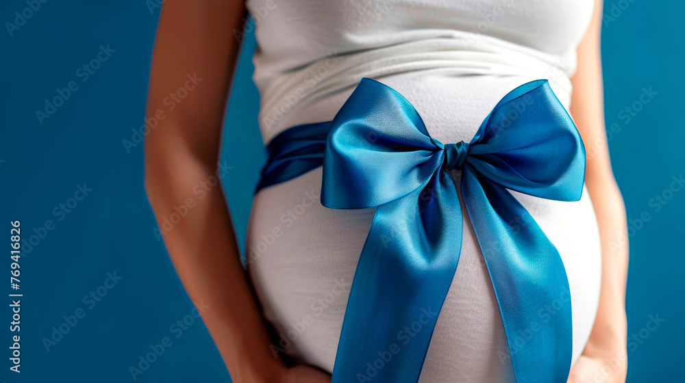 The belly of a pregnant woman in close-up, tied with a ribbon with a bow. The belly of a pregnant woman in close-up, tied with a ribbon with a bow.