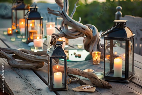outdoor table with lanterns, driftwood, and a centerpiece of floating candles photo