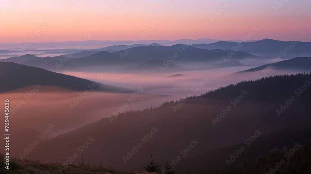 Naklejka premium A mountain range with a sun setting in the background