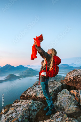 Mother hiking with infant baby outdoor family travel lifestyle in Norway summer vacations in Lofoten islands woman backpacking with child in mountains, love happy candid emotions - Mothers day holiday