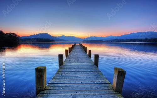 wooden jetty extending into the serene waters of the Lake District, with distant mountains