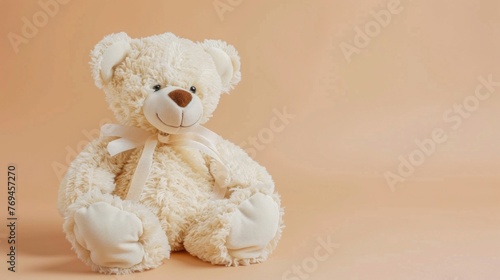 A white teddy bear sitting on a pink background