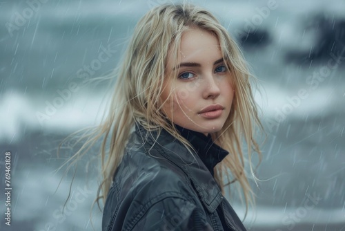 Amazing blond girl posing for photos at the beach in rainy morning